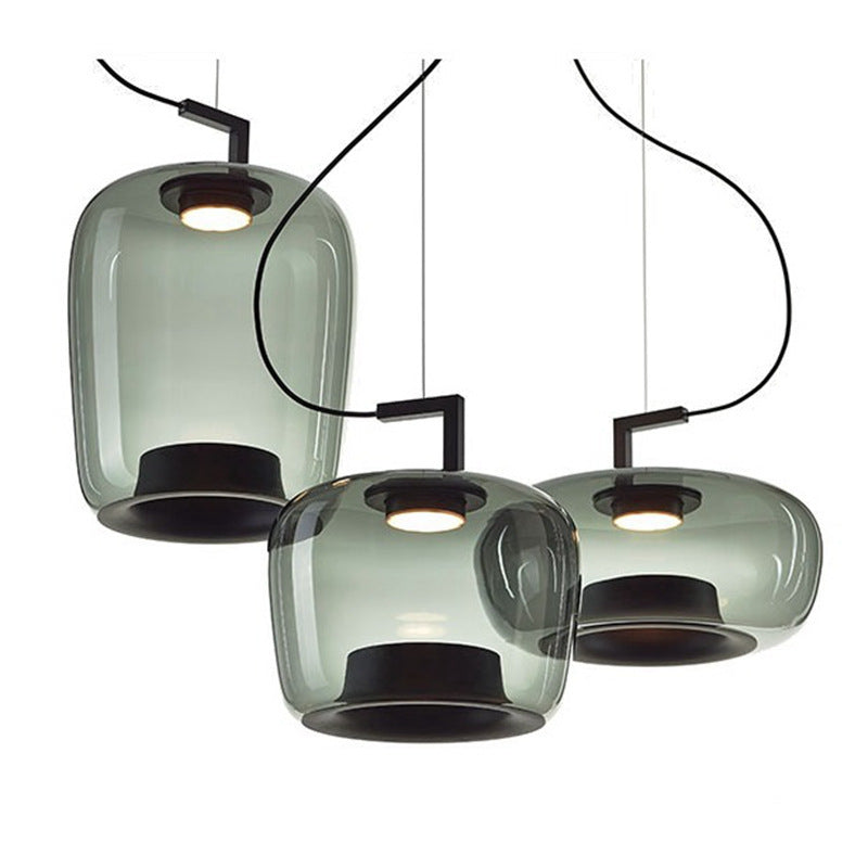 Nordic art glass pendant light glowing above a dark wood dining table