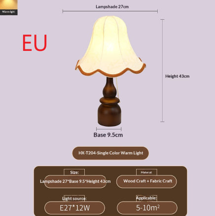 French-style vintage bedside lamp lit on a nightstand in a dim bedroom at dusk