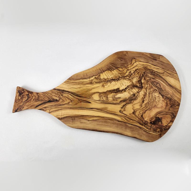 Wooden cutting board on dark slate with raking side light across the grain