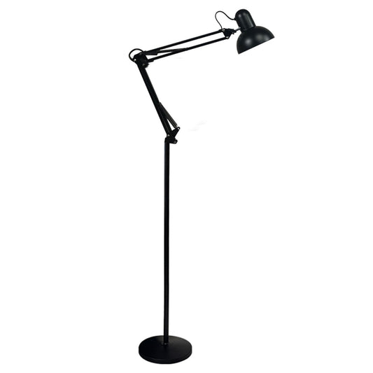 Floor lamp lit low beside a crib and nightstand at night