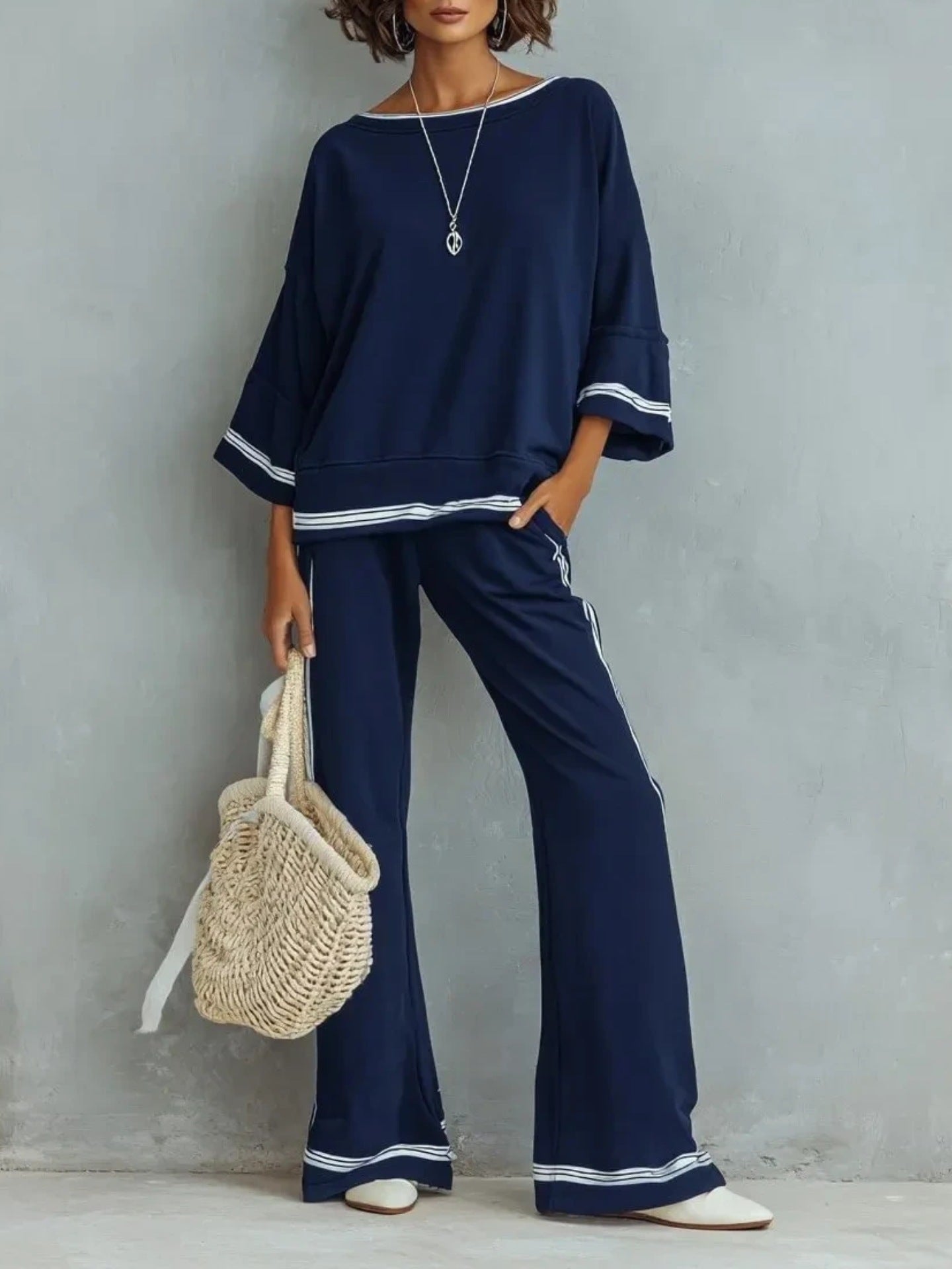 Full-length studio shot of the three-quarter sleeve wide-leg two-piece set on soft warm-grey seamless