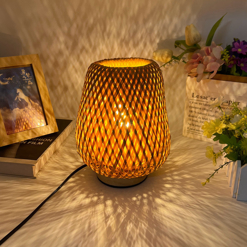 Minimal Japanese-style lamp lighting an open book on a desk in a dim room