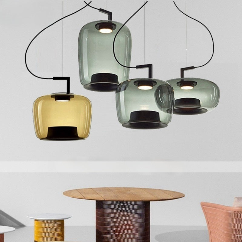 Three glass pendant lights clustered at staggered heights over a kitchen island